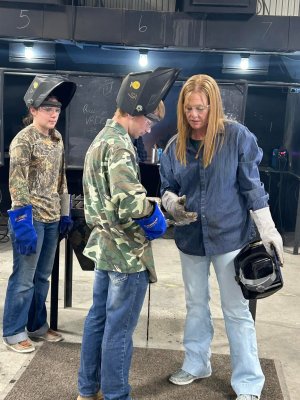 Agricultural educator works with students in Ag Mechanics lab