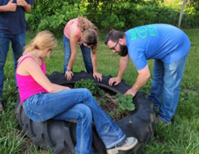 Agriculture educator works with students on flower bed