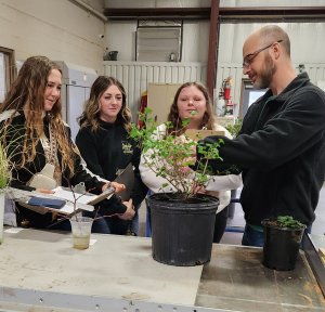 Agricultural educator works with student learning plant ID