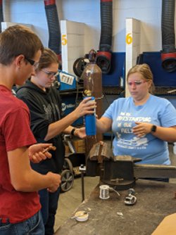 Agricultural educator helps students in ag mecahnics shop