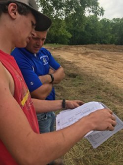 Agricultural educator works with student reading soil test results